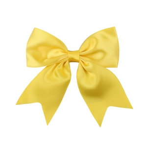 Detail of a bright yellow satin bow hair clip with smooth silk texture and fabric shine