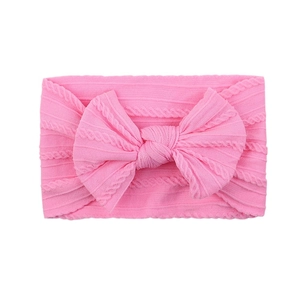 Pink knitted baby headband featuring a soft jacquard texture and large bow detail