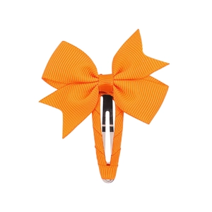 Detail showing the grooved texture of an orange grosgrain ribbon bow hair clip