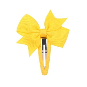 Detailed macro view of yellow grosgrain ribbon bow with fabric wrapped metal duckbill clip
