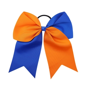 Close-up of dual-color orange and blue grosgrain ribbon cheer bow with elastic hair band