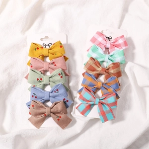 Détail du lot de 10 barrettes pour filles avec broderie cerise et motifs à carreaux chic