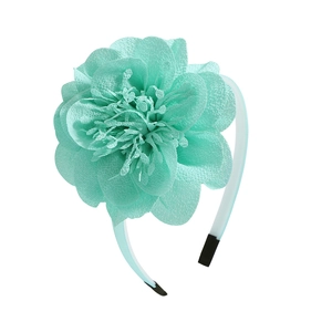 Détail d'un serre-tête fleur en mousseline vert menthe avec des pétales en tissu délicat