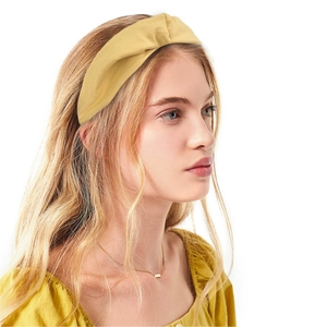 Detail of yellow fabric knotted headband on model for daily sports and facial cleansing