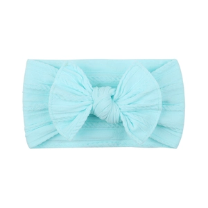 Detail of light blue nylon baby headband featuring cable knit texture and large bow knot
