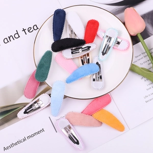Close-up of colorful velvet water-drop BB hair clips arranged on a decorative plate