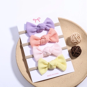 4-pack waffle knit baby bow headbands in soft pastel colors on a display card