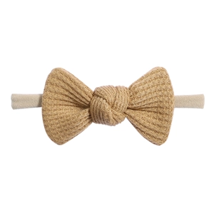 Close-up of khaki waffle knit fabric bow with high elastic nylon headband for babies