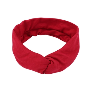 Detail view of the red twisted knot headband in soft breathable knitted fabric