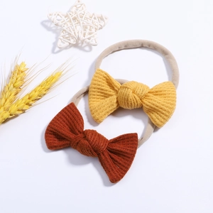 Two-pack of knotted waffle knit baby headbands in ginger and rust red with nylon bands