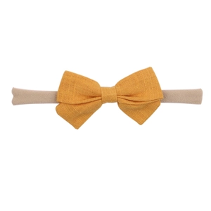 Close-up of yellow linen bow texture and high-elastic nylon baby headband detail