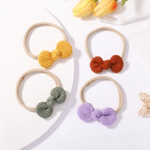 Set of four waffle knit baby headbands with knotted bows in warm solid colors for infants