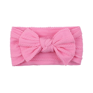 Soft pink cable knit nylon headband for infants featuring a large decorative bow