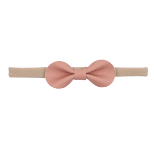 Detail of the soft elastic headband and pink leather bow with fine litchi texture