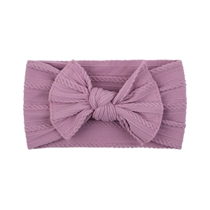 Detailed view of soft ribbed knit nylon baby headband with large dusty rose bow