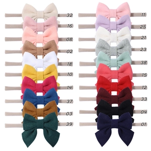 Flat lay of 20 colors infant soft nylon headbands with delicate fabric bows
