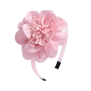 Detail of a large pink chiffon flower headband with layered petals and soft fabric texture