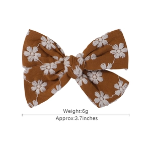 Floral embroidery bow hair clip in caramel fabric with white daisy patterns for women