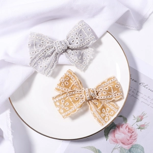 Pair of embroidered lace bow hair clips in mustard yellow and light grey colors
