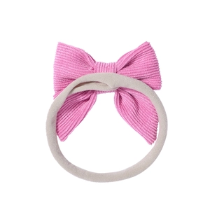 Dettaglio del fiocco in velluto a coste rosa e fascia elastica in nylon per neonati