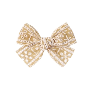 Vue détaillée du nœud en mousseline jaune gingembre avec broderie florale pour cheveux
