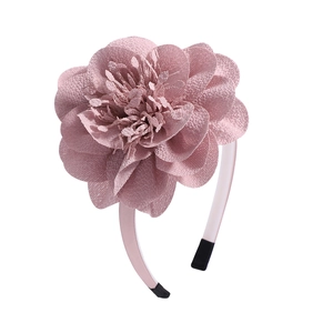 Close-up of light pink chiffon flower headband with multi-layered petals and ribbon wrap