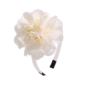 Detail of large white chiffon flower headband showing layered petals and fabric texture