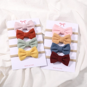 Détail d'un lot de huit bandeaux bébé en velours côtelé avec nœuds multicolores