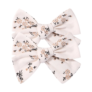 Close-up of floral print cotton linen bow hair clips set on a plain white background