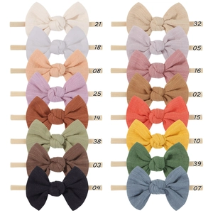 Flat lay of 16-color nylon baby headbands set in soft Morandi shades and fabric bows