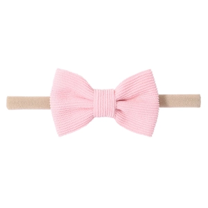 Détail du nœud en velours côtelé rose sur un bandeau pour bébé en nylon élastique