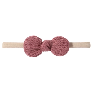 Detailed waffle knit texture of dust pink bow headband with soft nude nylon strap