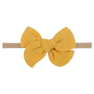 Detailed texture of yellow linen bow on high-elasticity nylon headband for baby hair