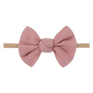 Detailed close-up of pink linen bow on soft elastic nylon headband for babies