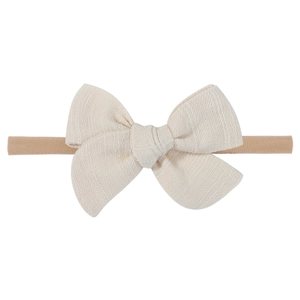 Detailed view of handmade cream fabric bow on a soft brown nylon baby headband