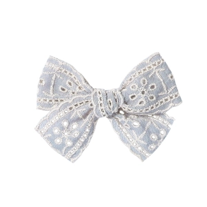 Détail du nœud de cheveux en coton bleu clair avec broderie florale en dentelle blanche