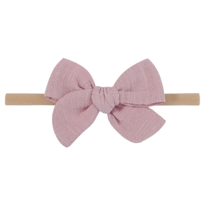Detailed texture of light pink linen bow headband with high-elastic nylon band for infants