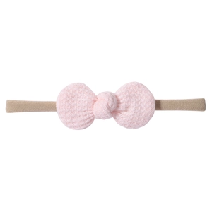 Detail showing pink waffle knit bow and soft elastic nylon headband for babies