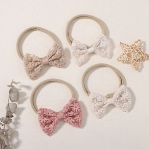 Détail d'un lot de 4 bandeaux pour bébé avec nœuds papillon en dentelle et nylon nude