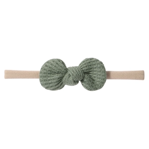 Detail of sage green waffle knit bow headband for infants with elastic nude nylon band
