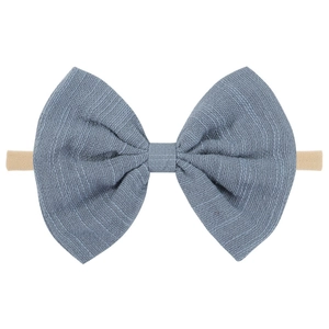 Detail of baby headband with a textured dusky blue bow and a soft nylon elastic band