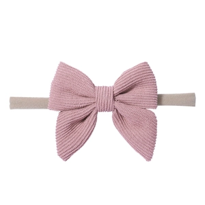 Dettaglio del fiocco in velluto a coste rosa su fascia per neonati in tessuto elastico