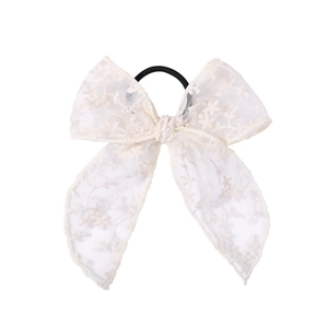 Detailed macro view showing the delicate lace embroidery and texture of the bow hair tie