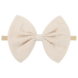 Detail view of a soft cream nylon headband with a large textured bow for baby girls