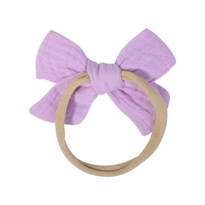 Close-up of a soft lavender cotton bow headband with elastic nude nylon for infants
