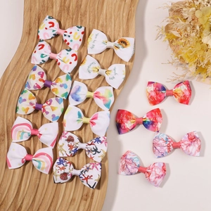 Détail de 14 pinces à cheveux à nœuds colorés en ruban gros-grain aux motifs arc-en-ciel