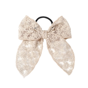 Detail of beige lace bow hair tie with floral embroidery and flexible elastic rope