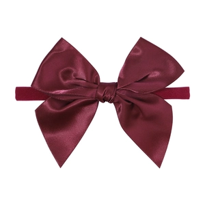 Detailed view of burgundy satin bow headband made of high-gloss silk for baby hair styling