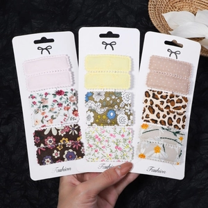 Close-up of floral fabric snap hair clips set with various patterns on white card