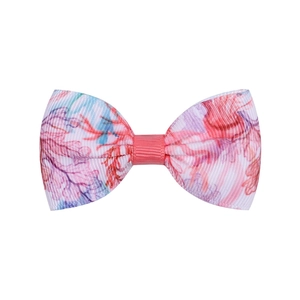 Détail d'une pince à cheveux nœud coloré pour enfants avec motif floral et texture côtelée